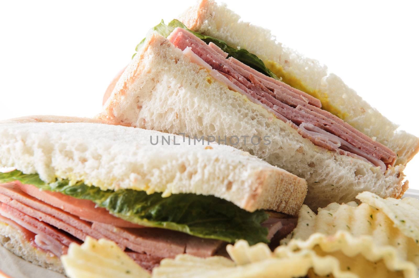 Closeup of a bologna sandwich with potato chips, isolated on a white background.