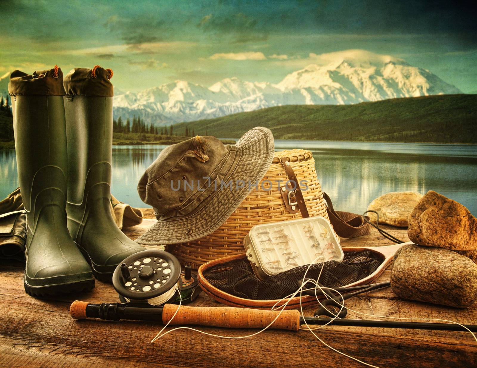 Fly fishing equipment on deck with view of a lake and mountains by Sandralise