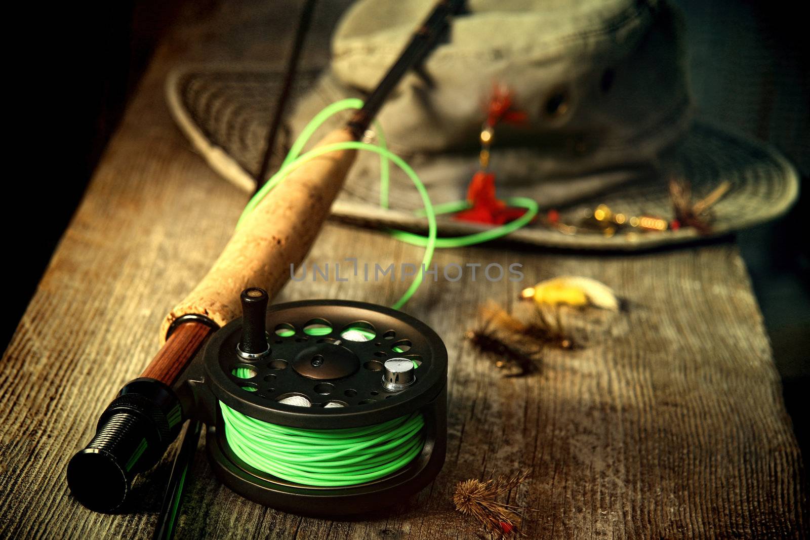 Fly fishing equipment with old hat on bench by Sandralise