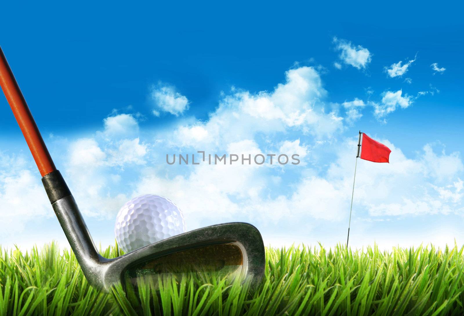 Golf ball with tee in the grass against blue sky