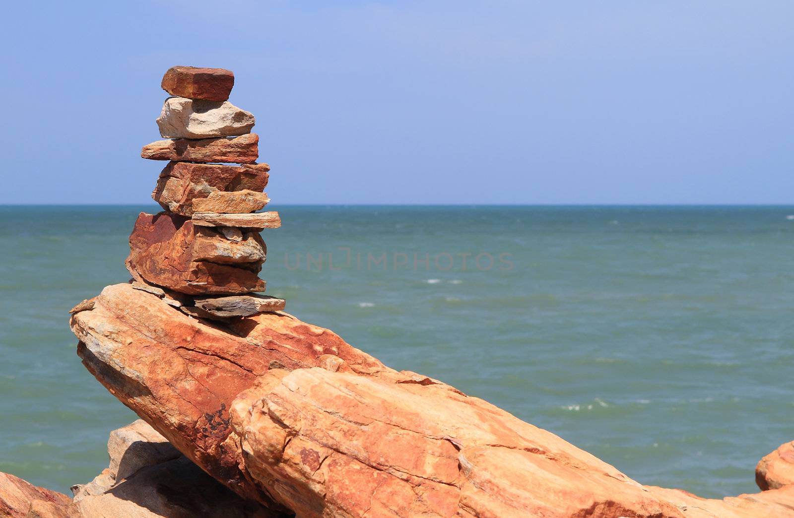 Pebble stone pyramid against blue sea