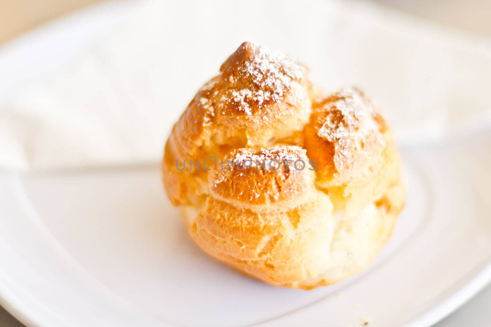 Delicious cream filled pastry sprinkled with powdered sugar served on a plate