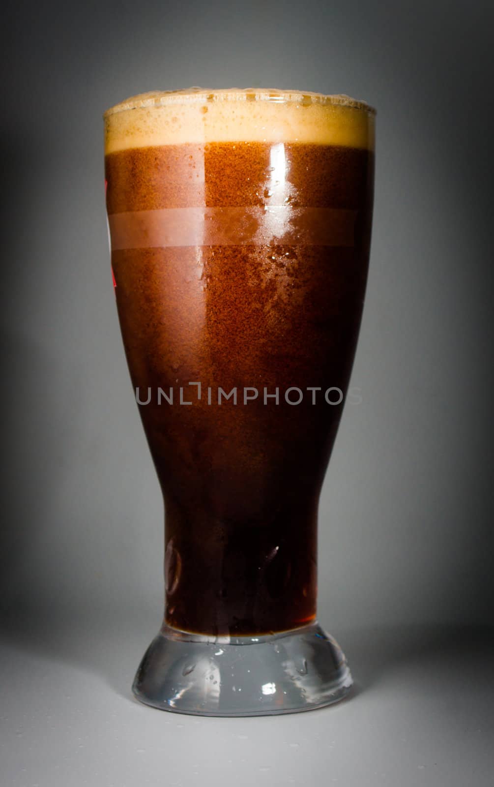 Beer glass full of cold dark beer. Isolated