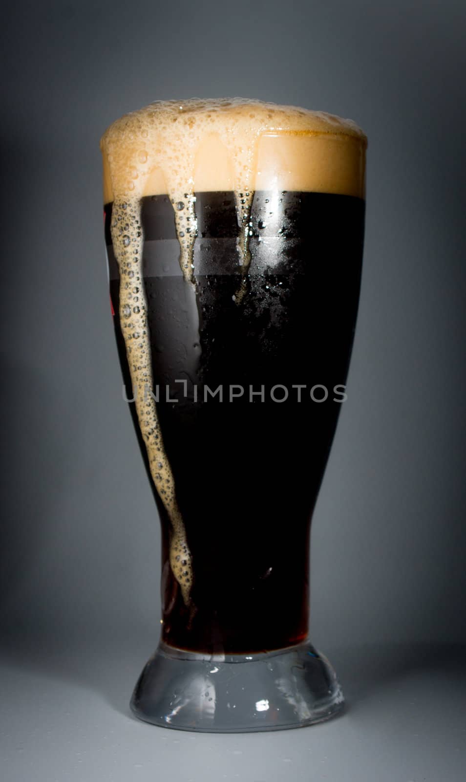Beer glass full of cold dark beer. Isolated