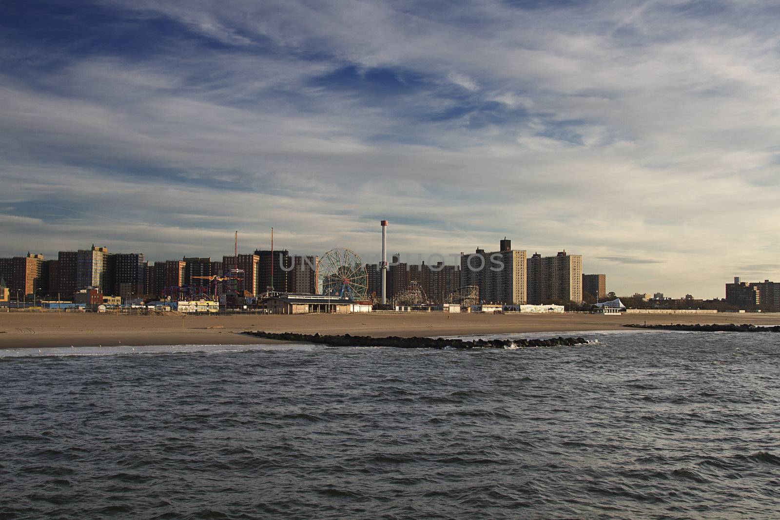 Coney Island beach at sunrise with building in the background and ocean in the foreground