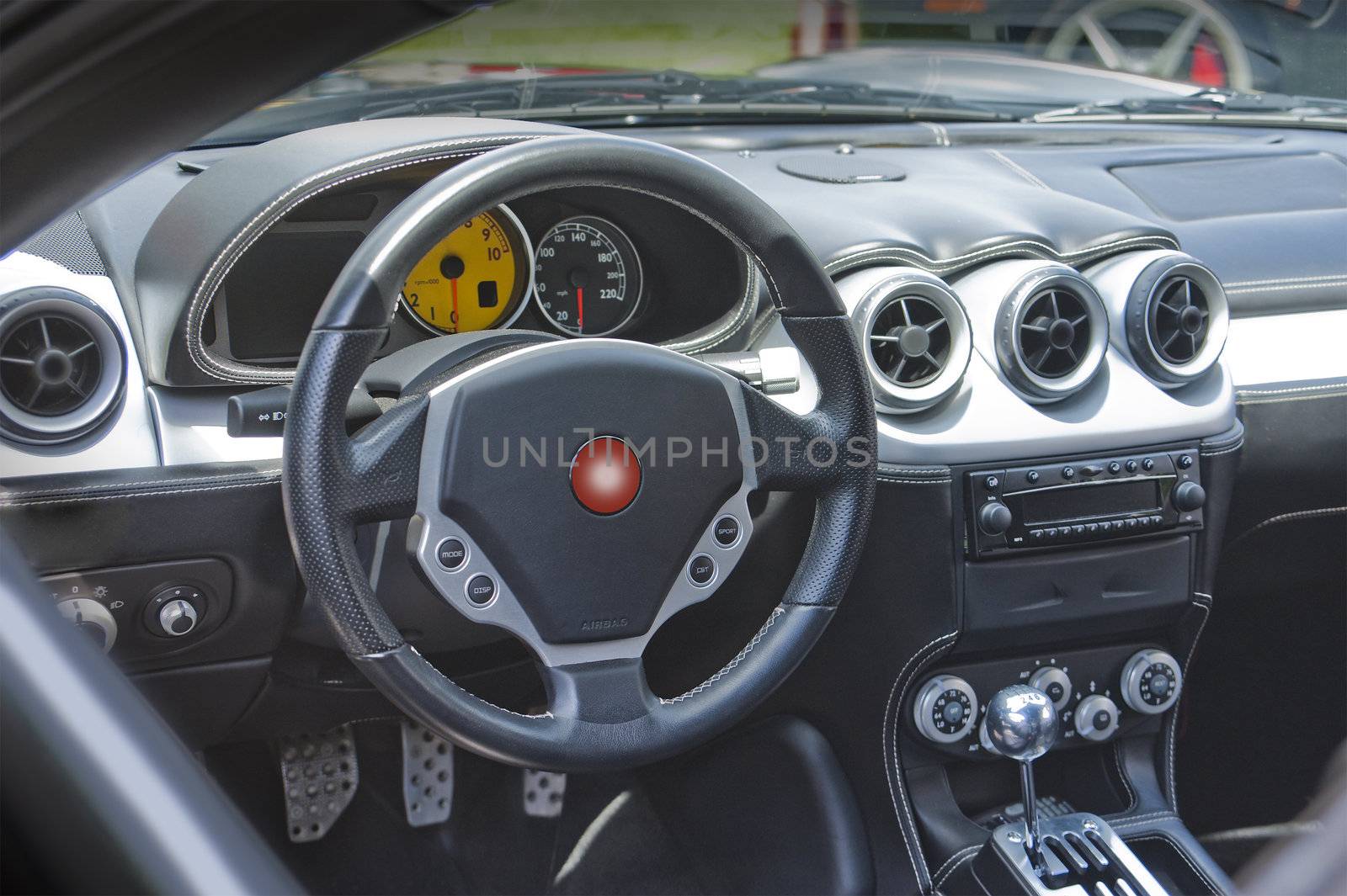 Sports car interior in gray leather and carbon fiber