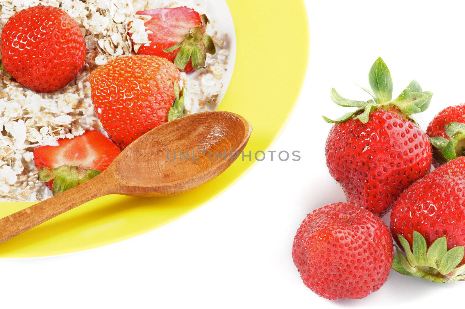 Healthy Muesli, Milk and Fresh Strawberry on Yellow plate with Wooden Spoon isolated on white background