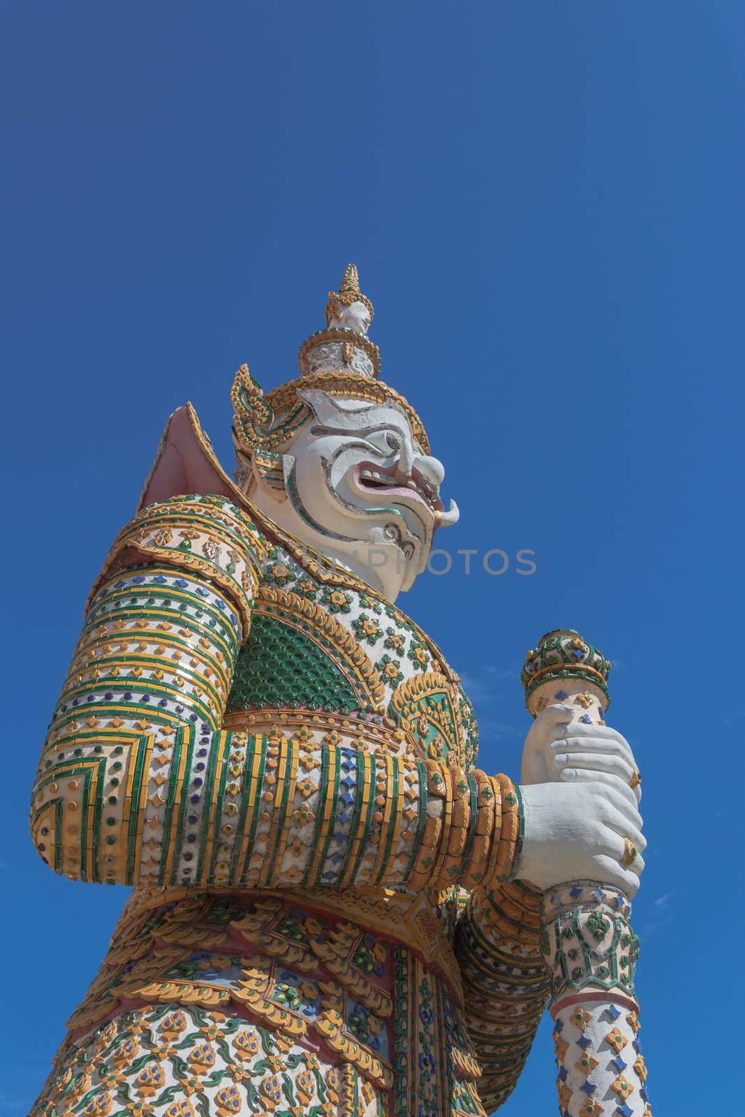 Demon Guardian statue at the Temple of Dawn was beautifully decorated with tiny pieces of colored ceramics and Chinese porcelain placed delicately into intricate patterns. It is one of Bangkok's world-famous landmarks.