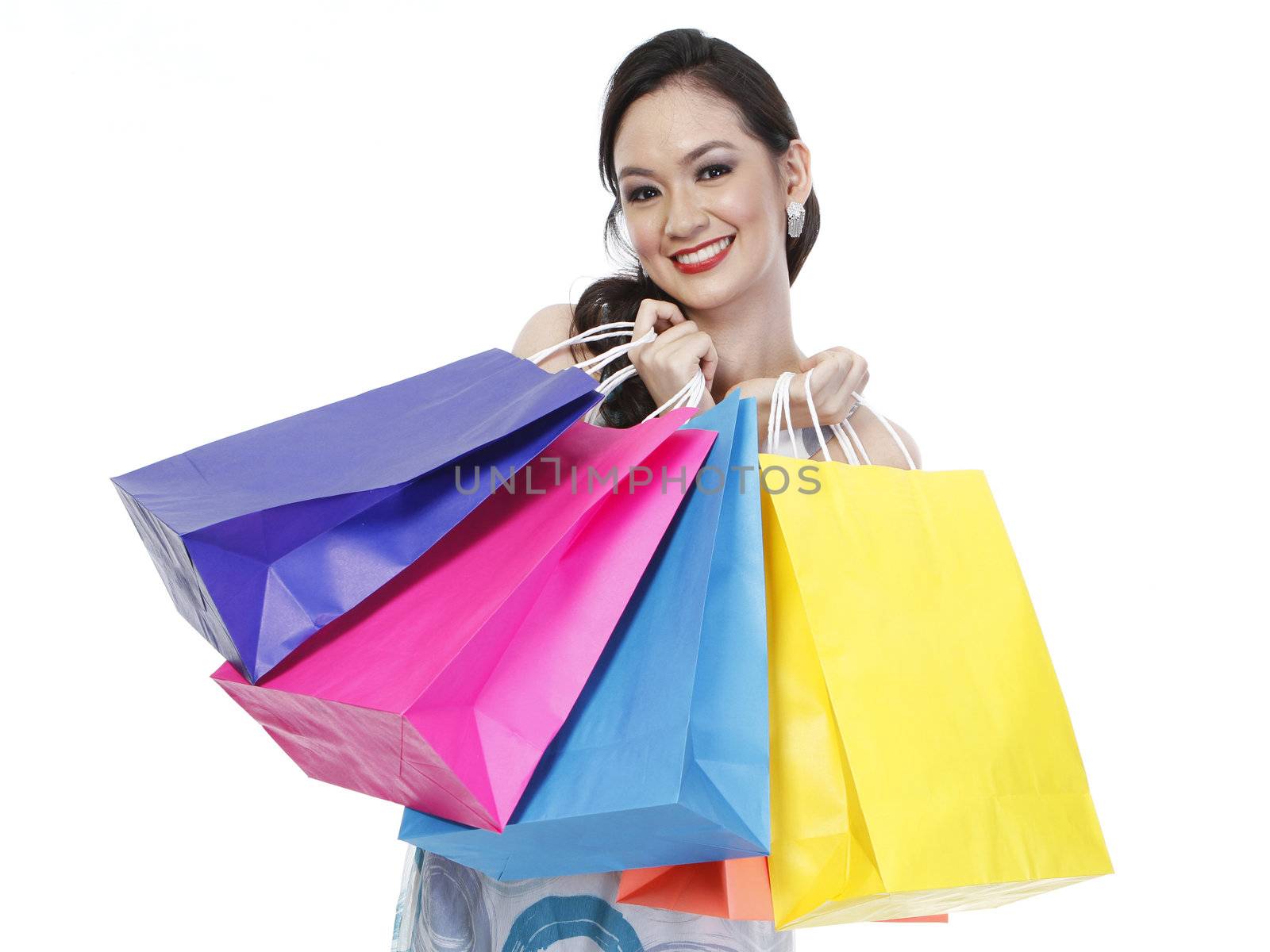 An attractive fashionable woman holding colorful paper shopping bags (isolated on white)