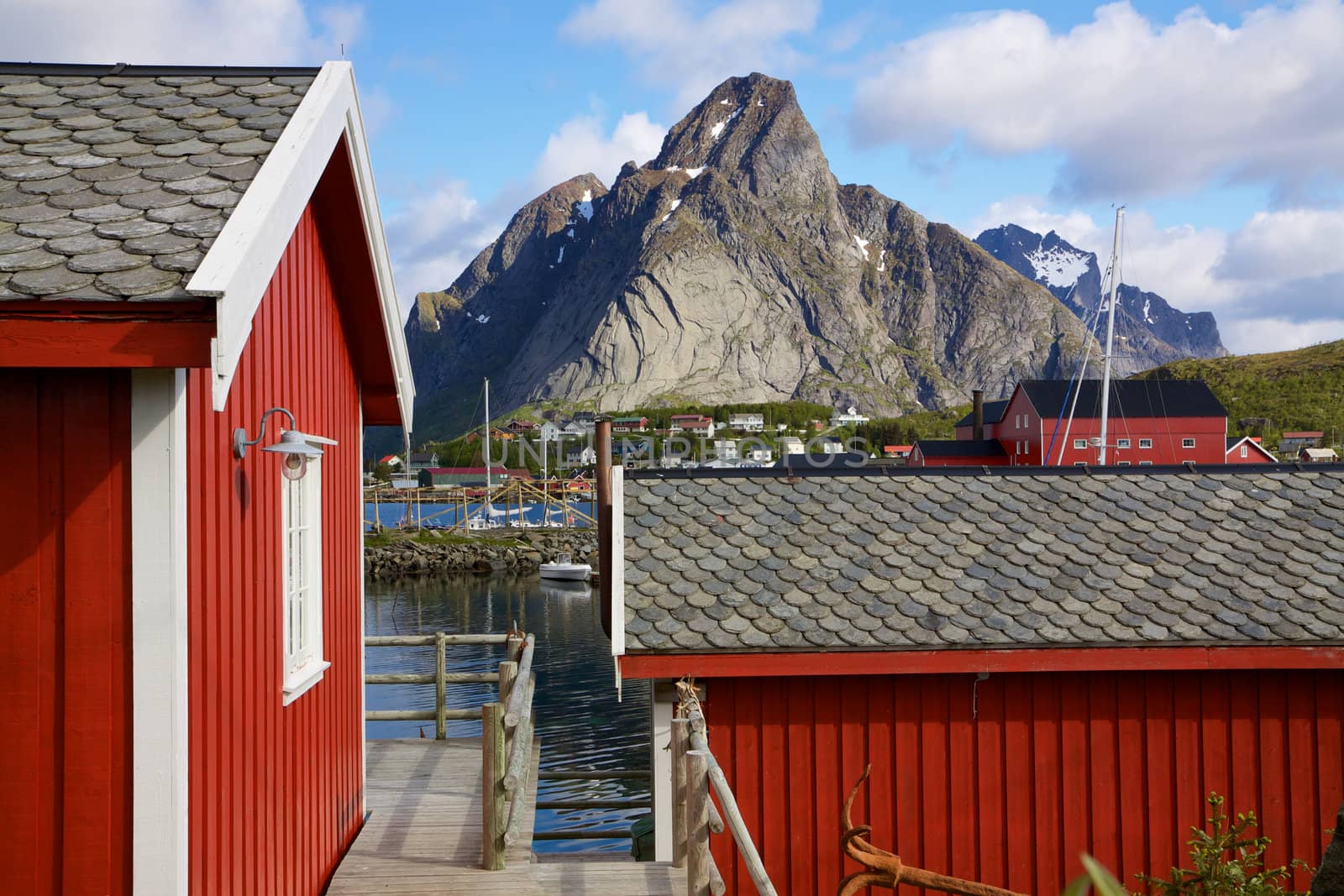 Red fishing rorbu huts by the fjord in town of Reine on Lofoten islands