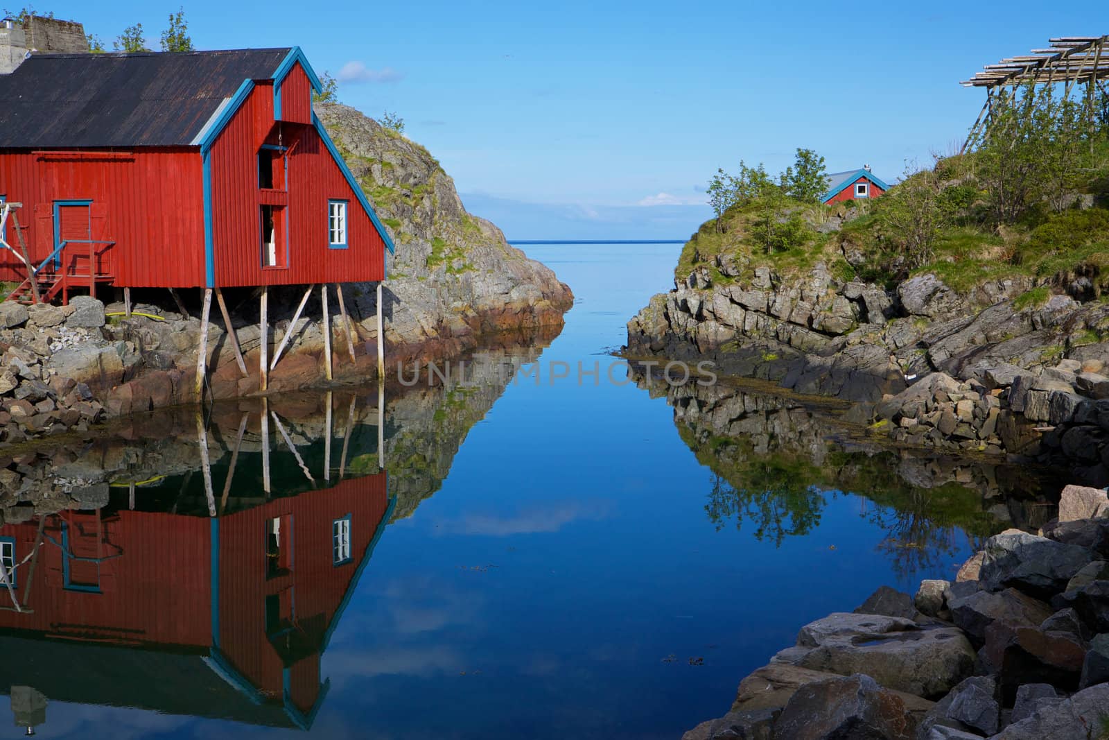 Picturesque red fishing hut on the coast of fjord on Lofoten islands in Norway