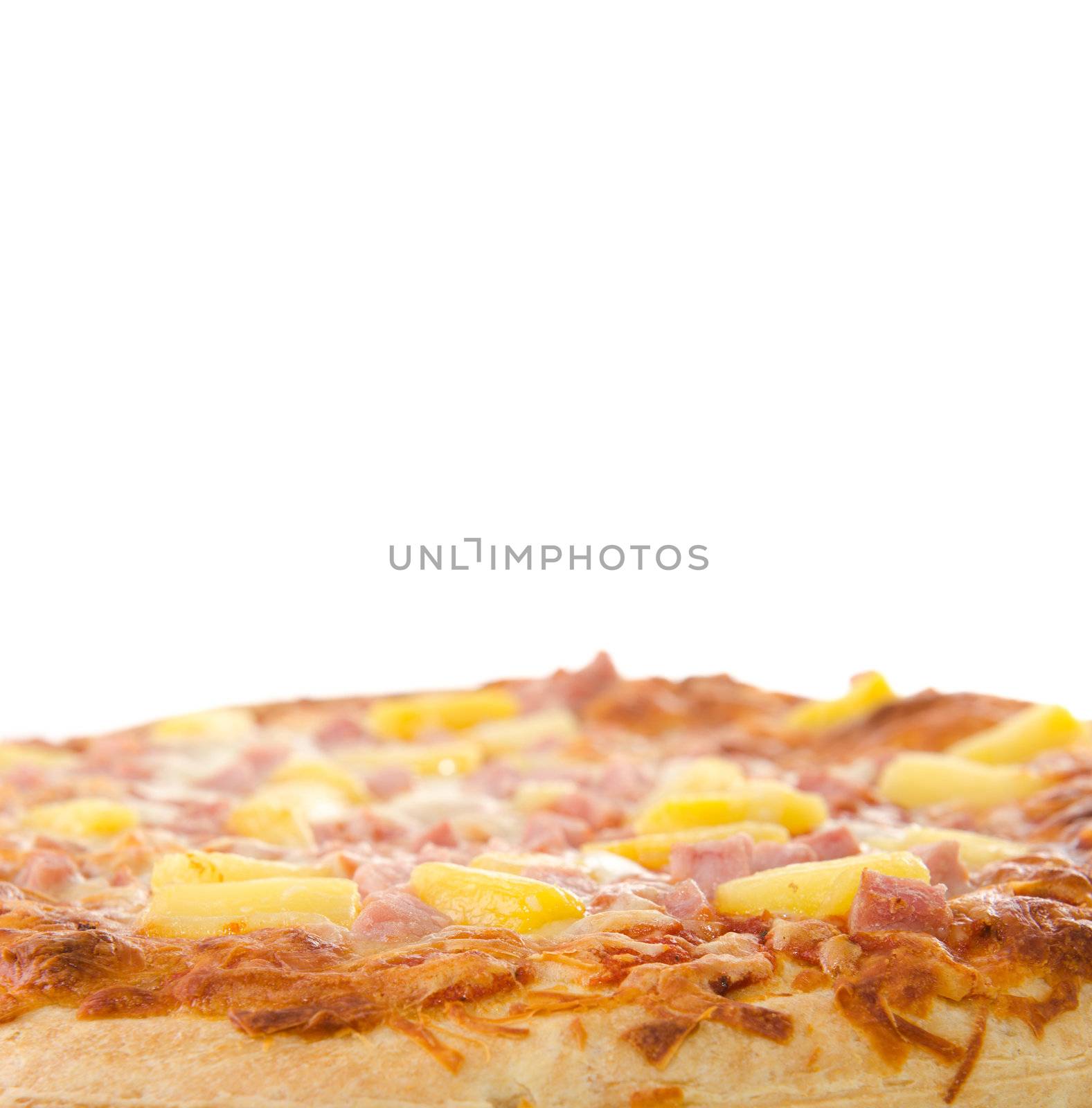 A cooked hawaiian pizza with white copyspace above.