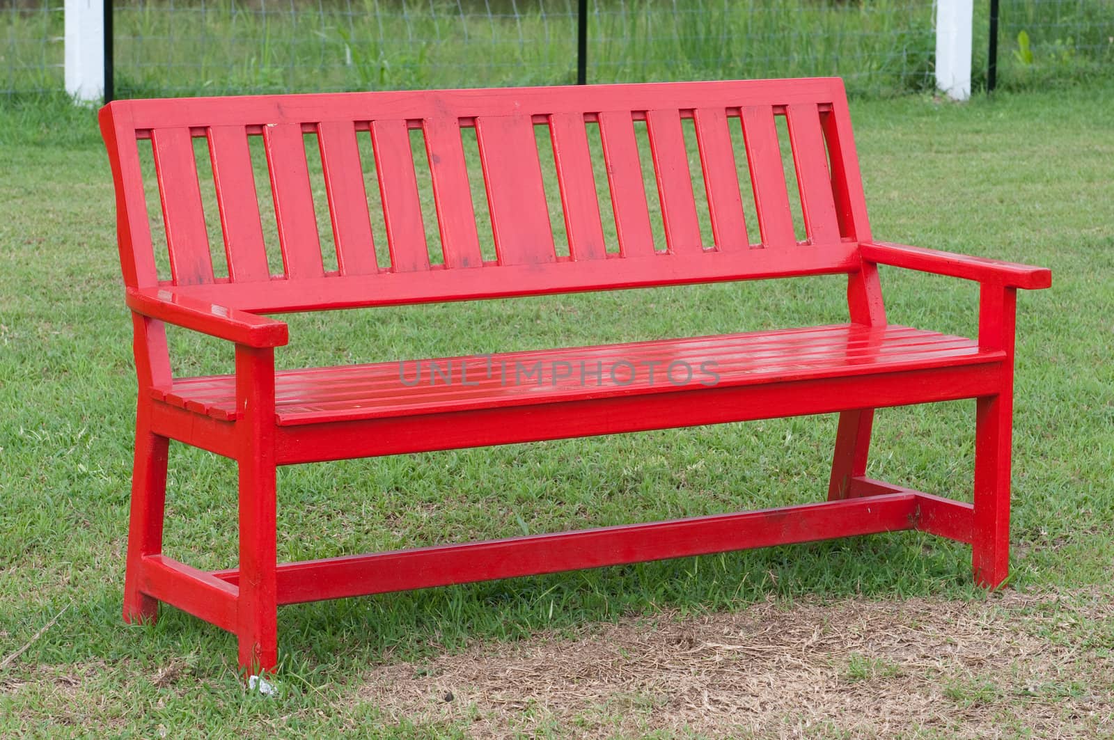 Lonely red wooden bench in the park 