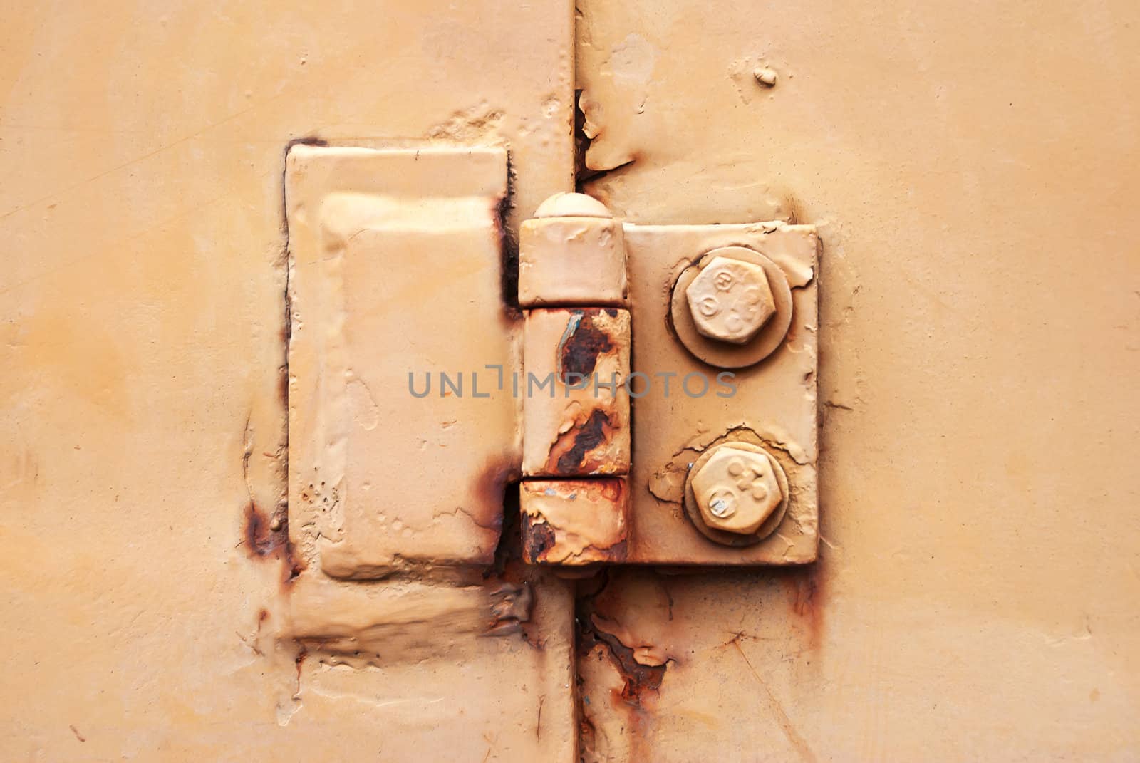 Old rusty metal hinge On The Yellow Door