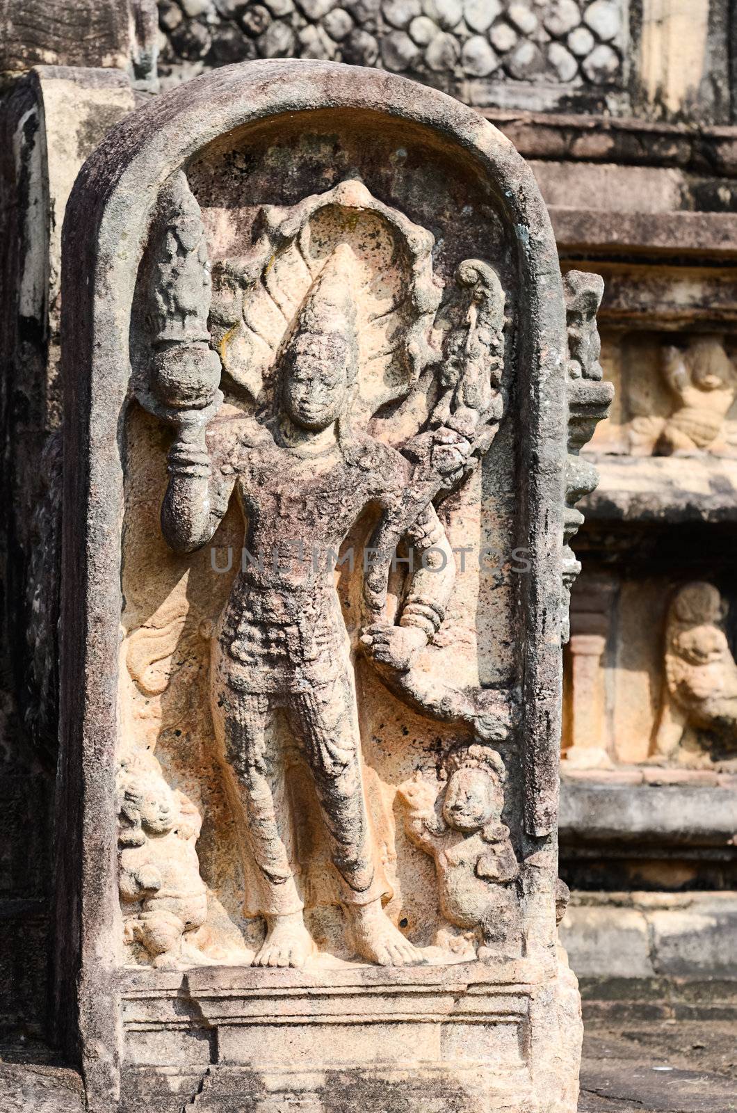 The legendary king of snakes Nagaraja - guard the gates of the antique temple, Sri Lanka. He holds the pot of plenty (punkalasa) and a sprouting branch complete with leaves, buds and flowers.