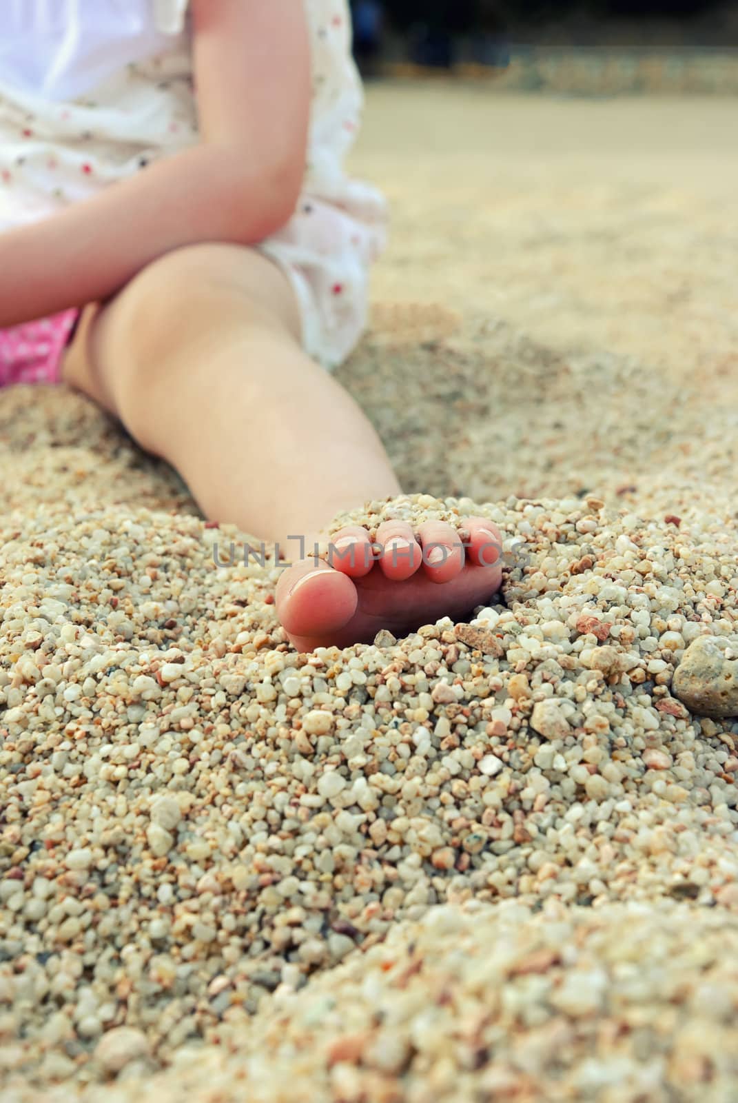 Close up toddler foot on a sandy beach by dmitrimaruta