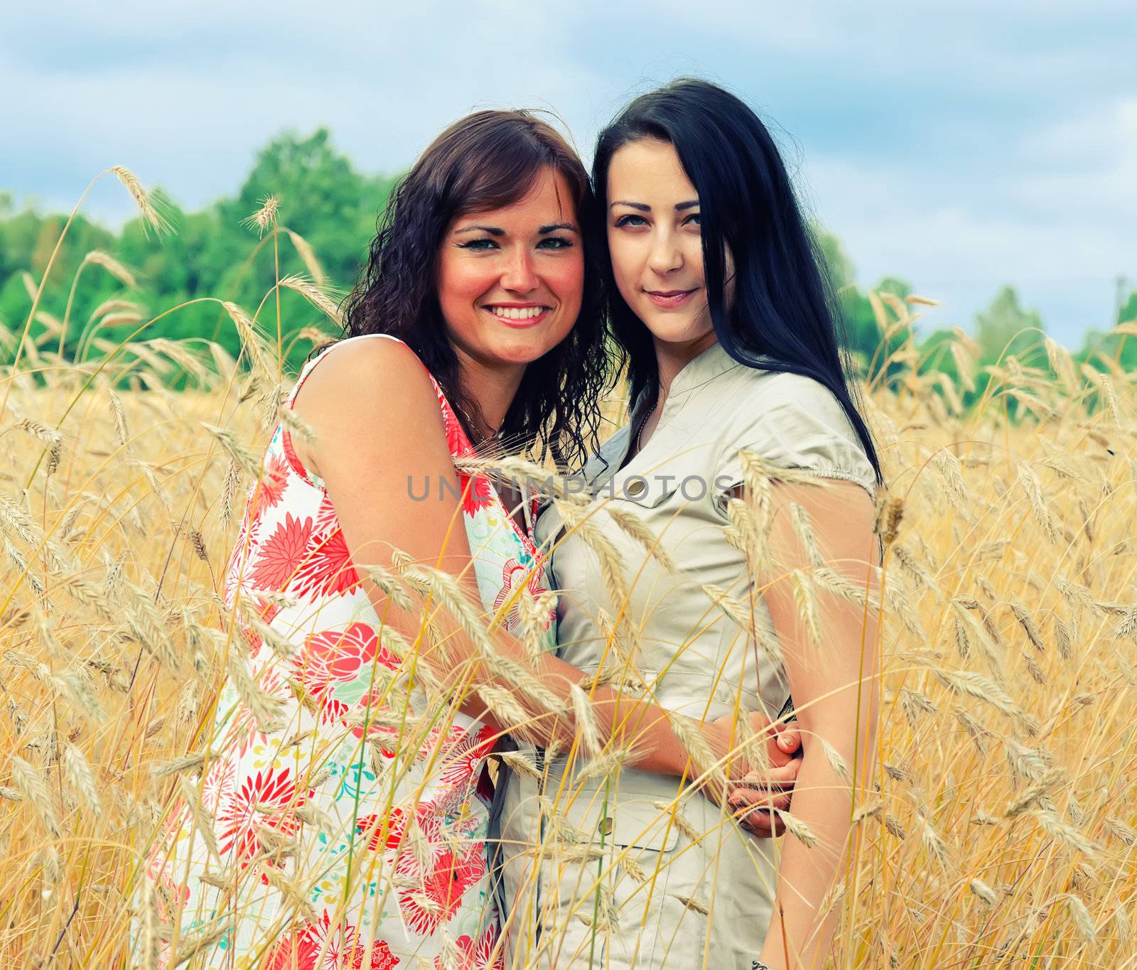 Portrait of two brunet woman in the field