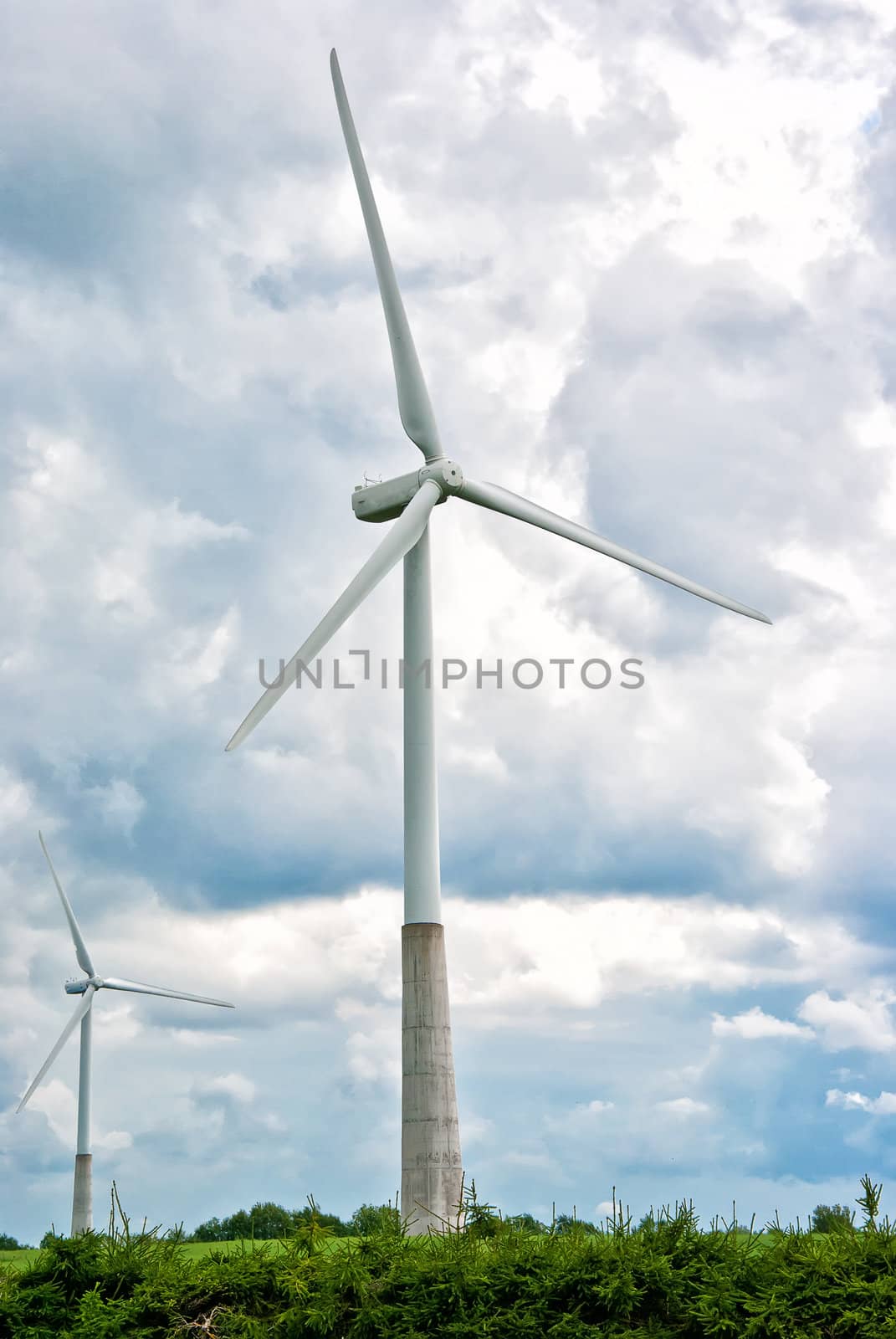 Two wind turbines on a cloudy sky background by dmitrimaruta