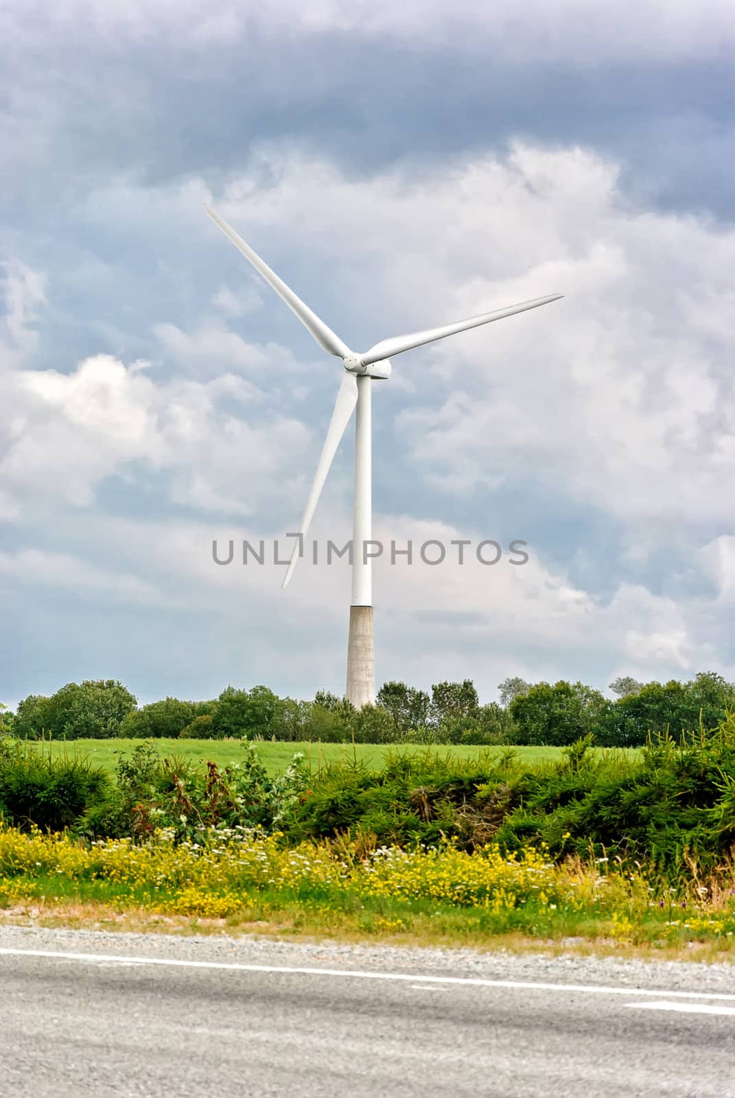 Wind turbine on a cloudy sky background