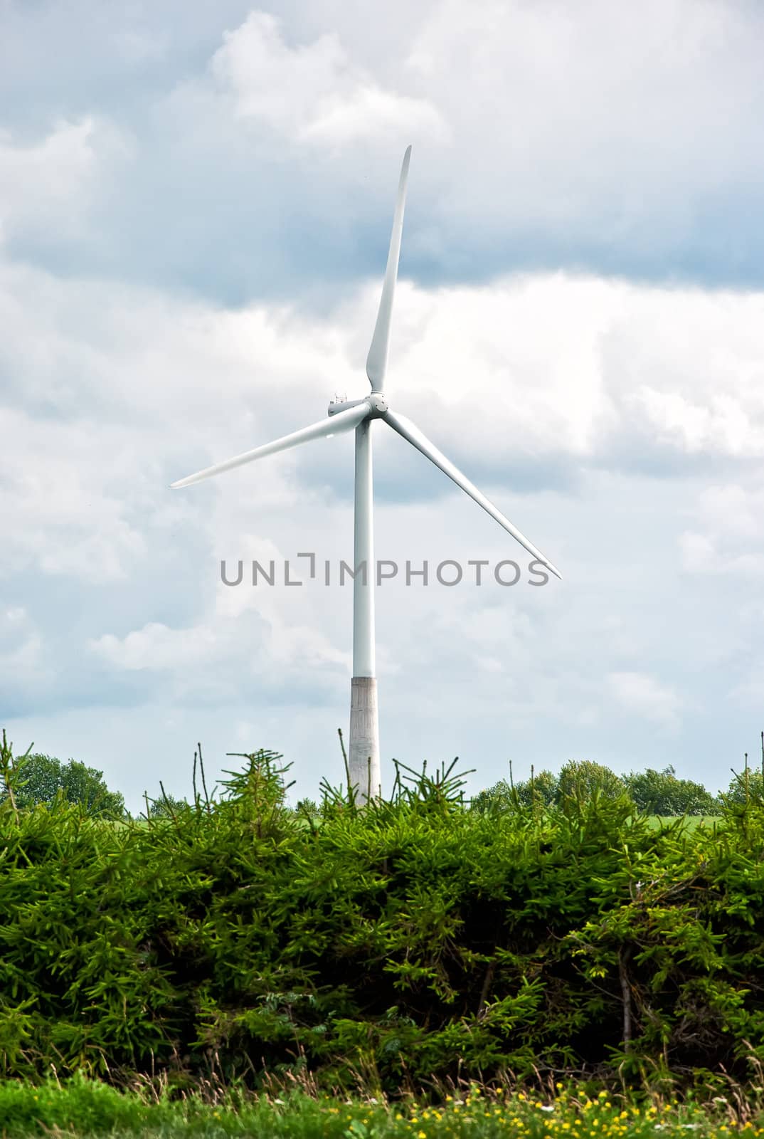 Wind turbine on a cloudy sky background