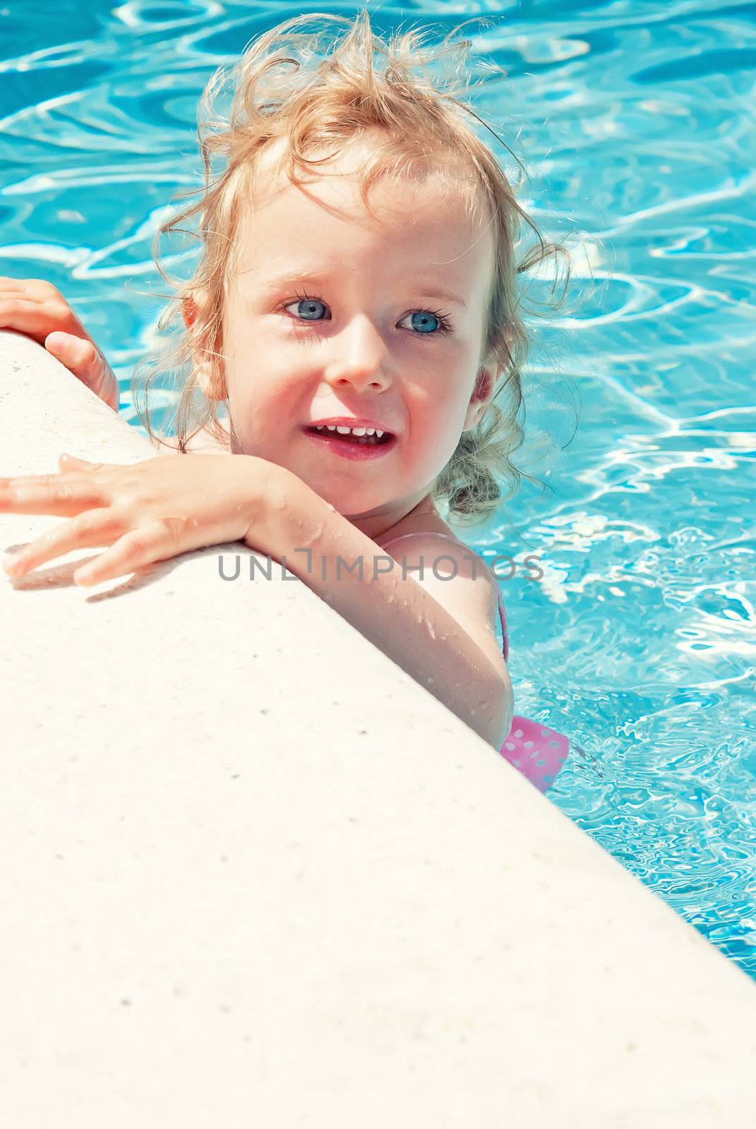 Cute little girl having fun in the swimming pool by dmitrimaruta