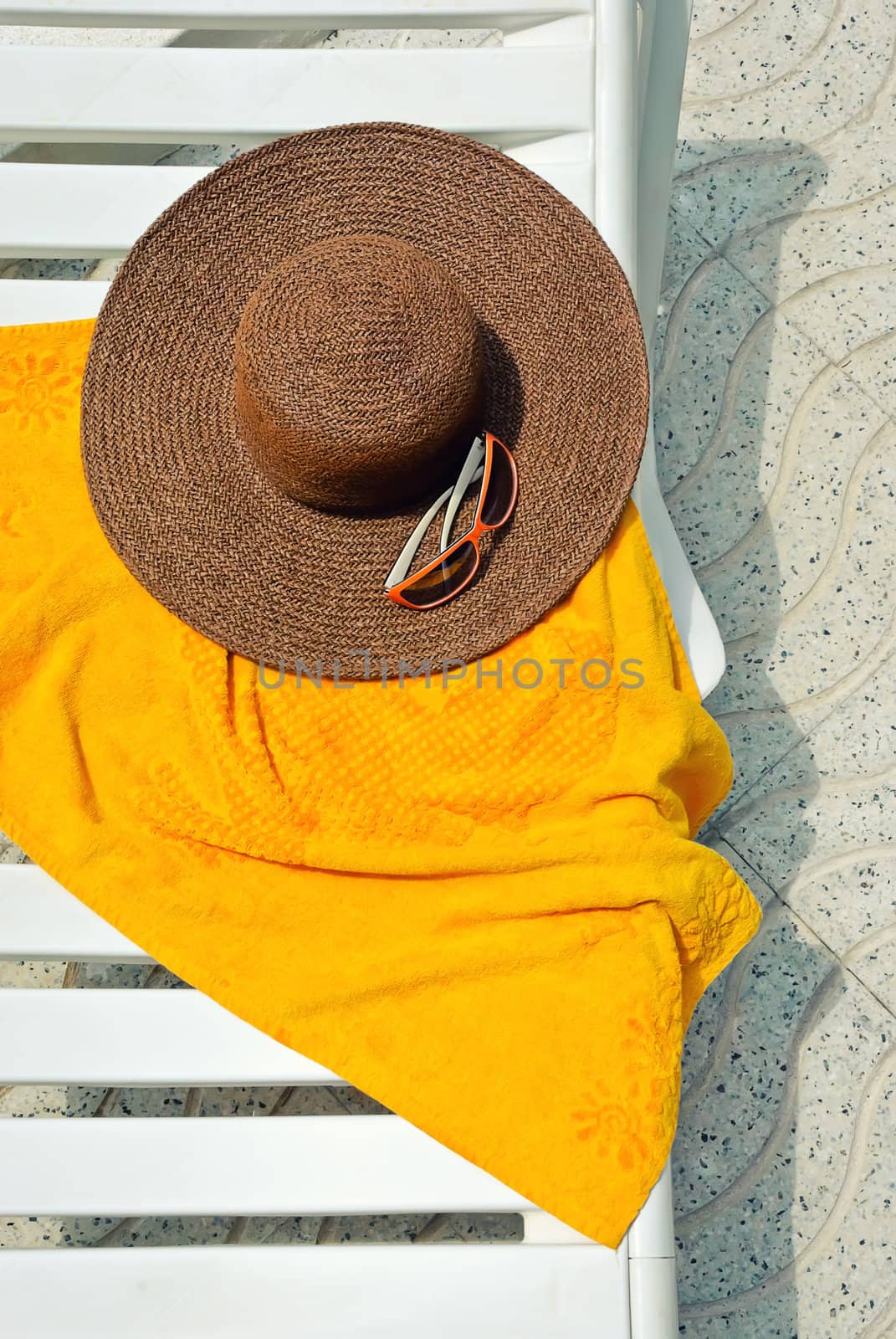 Straw hat with towel on the longue