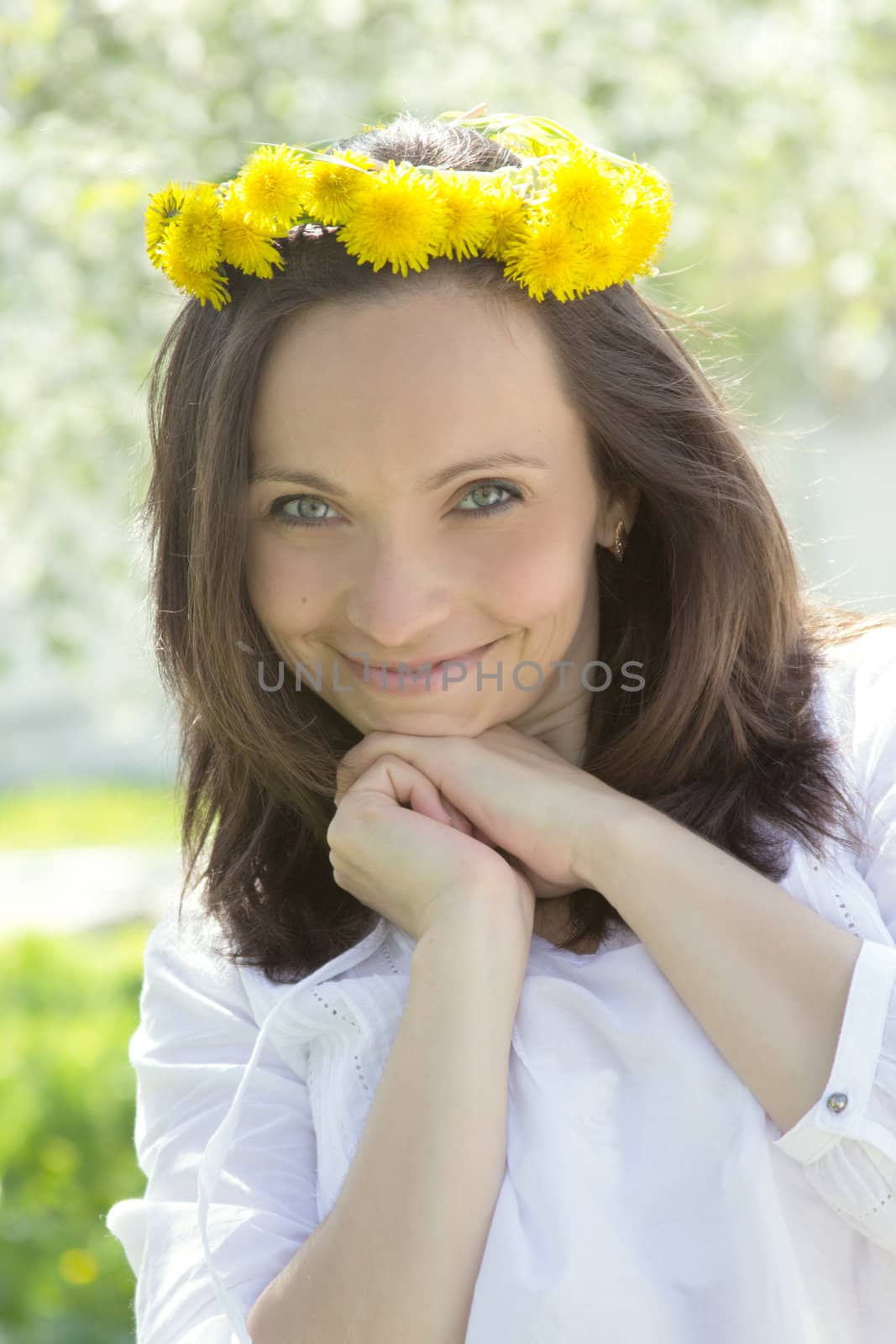 Sensual lovely woman with dandelion wreath in spring