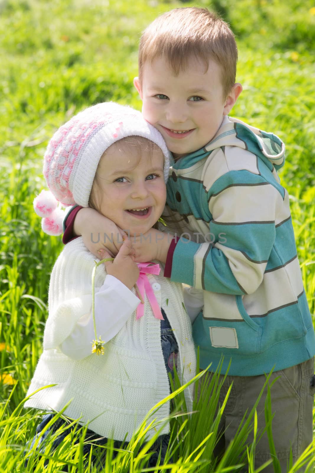 Brother giving hug to sister outdoors in spring