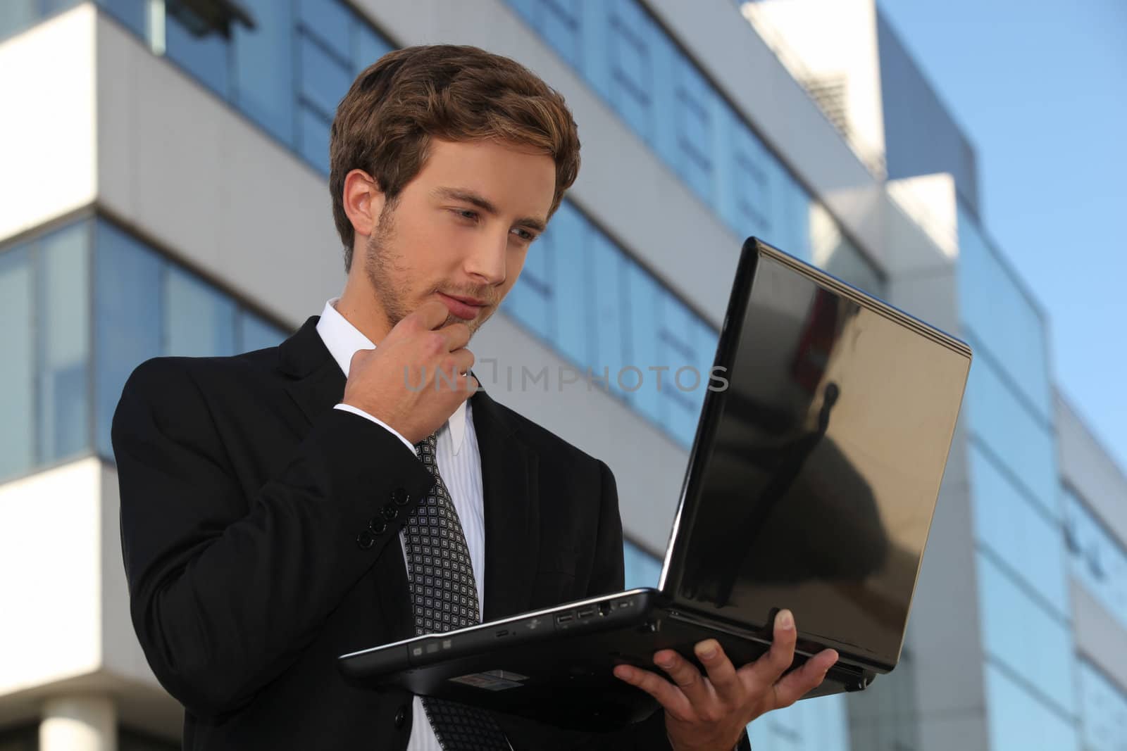 Handsome businessman using a laptop in the city