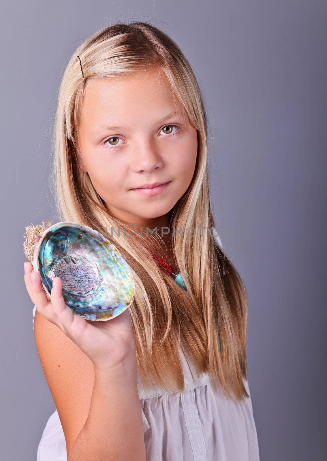 Beautifu young girl holding an open seashell 