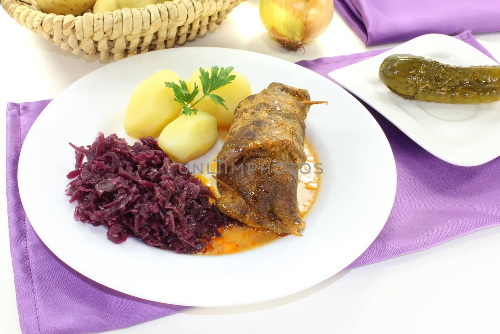 fresh roll of beef stuffed with onions, bacon and pickles on a light background