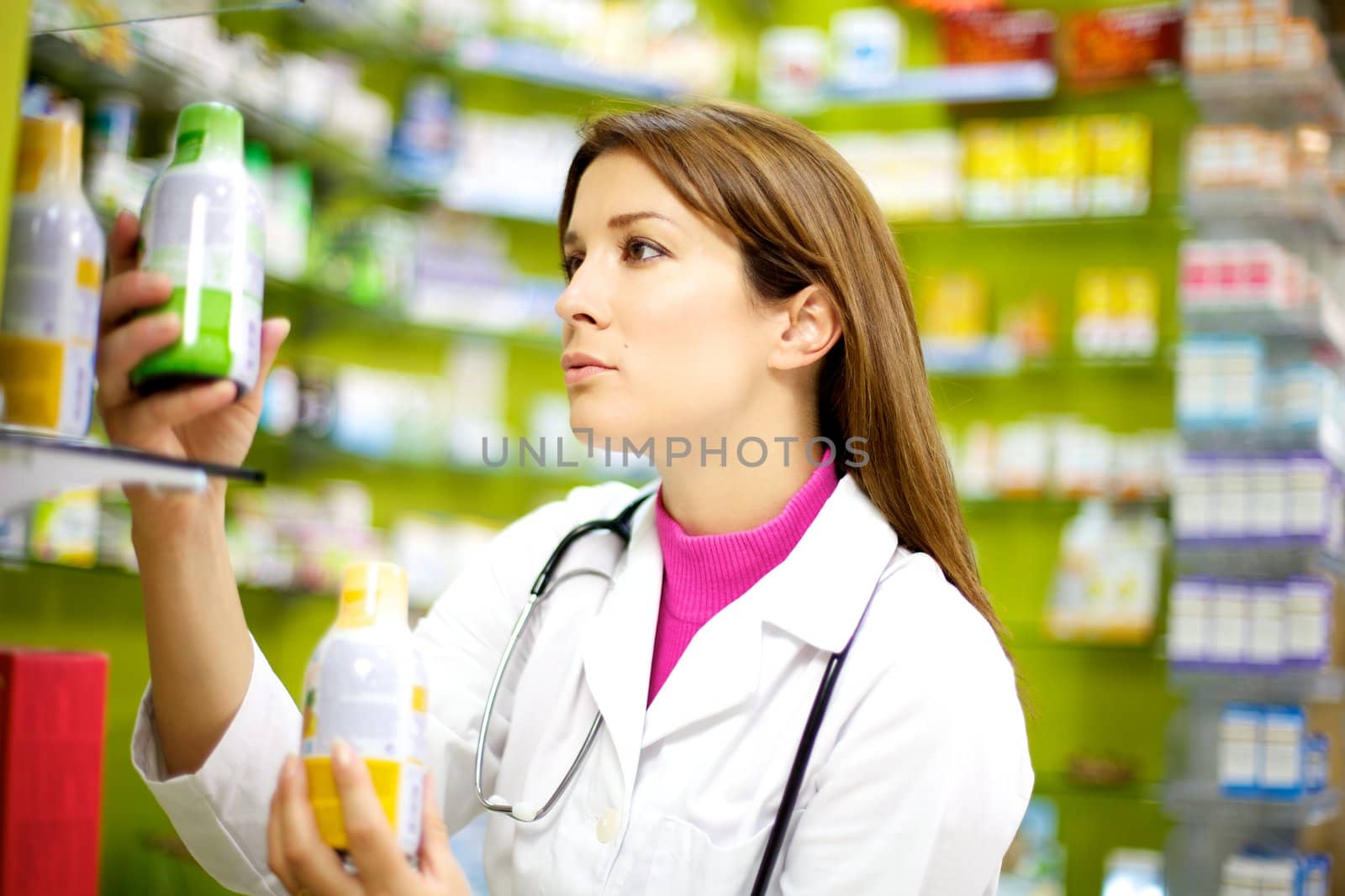 young good looking doctor putting order in her pharmacy with medicine