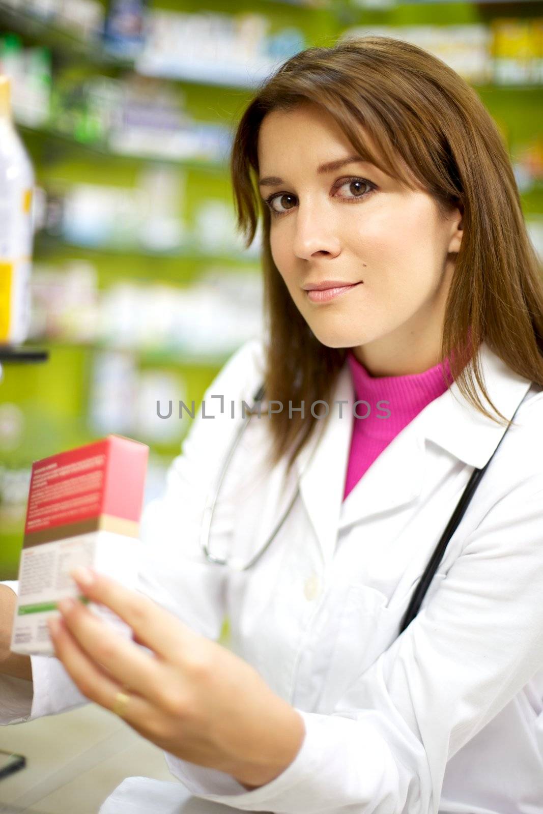 Young female doctor in pharmacy smiling by fmarsicano
