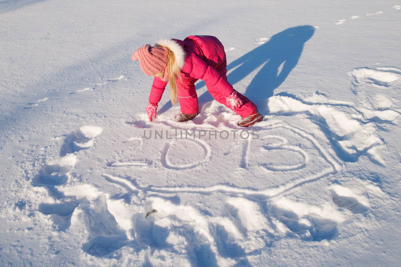 a little girl writes 2013  in the snow 
