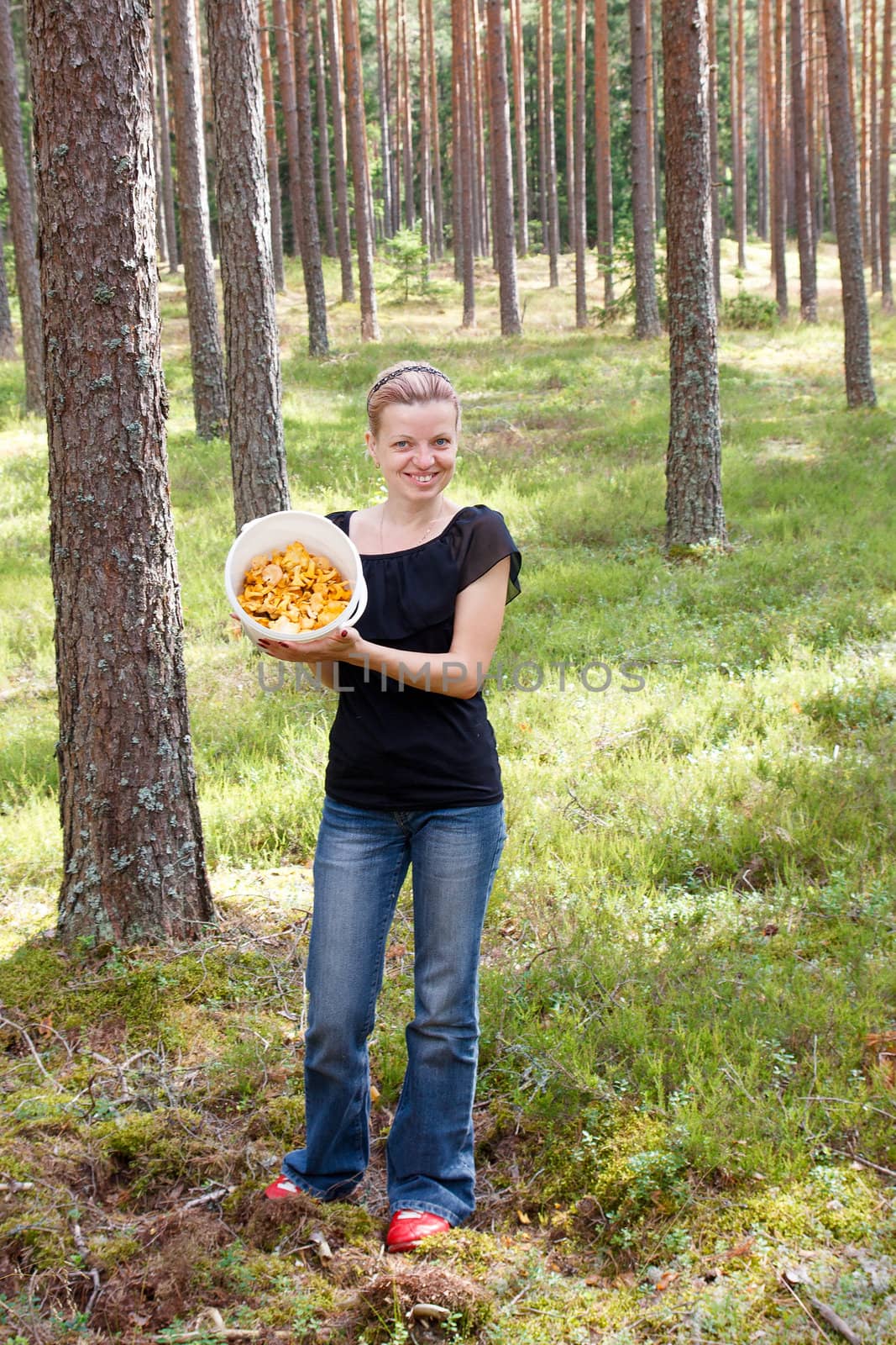 woman shows a bucket full of mushrooms