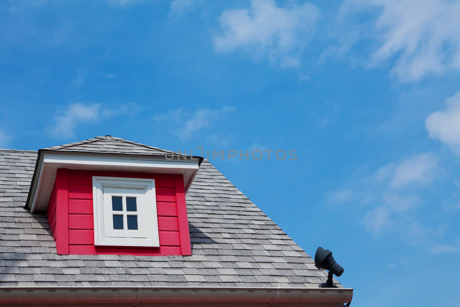red dormer on the roof of a wood home
