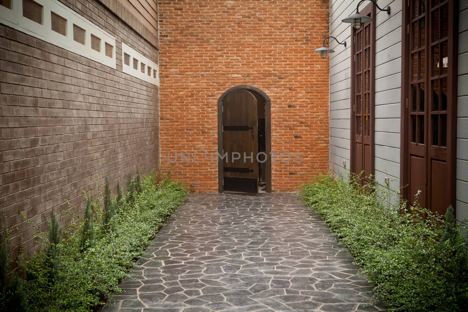 Elegant stone walkway and wood door on brick wall