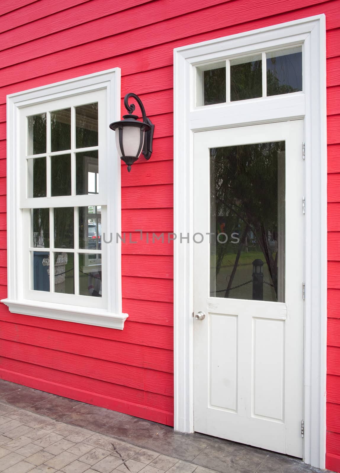 red wood wall with white window and door