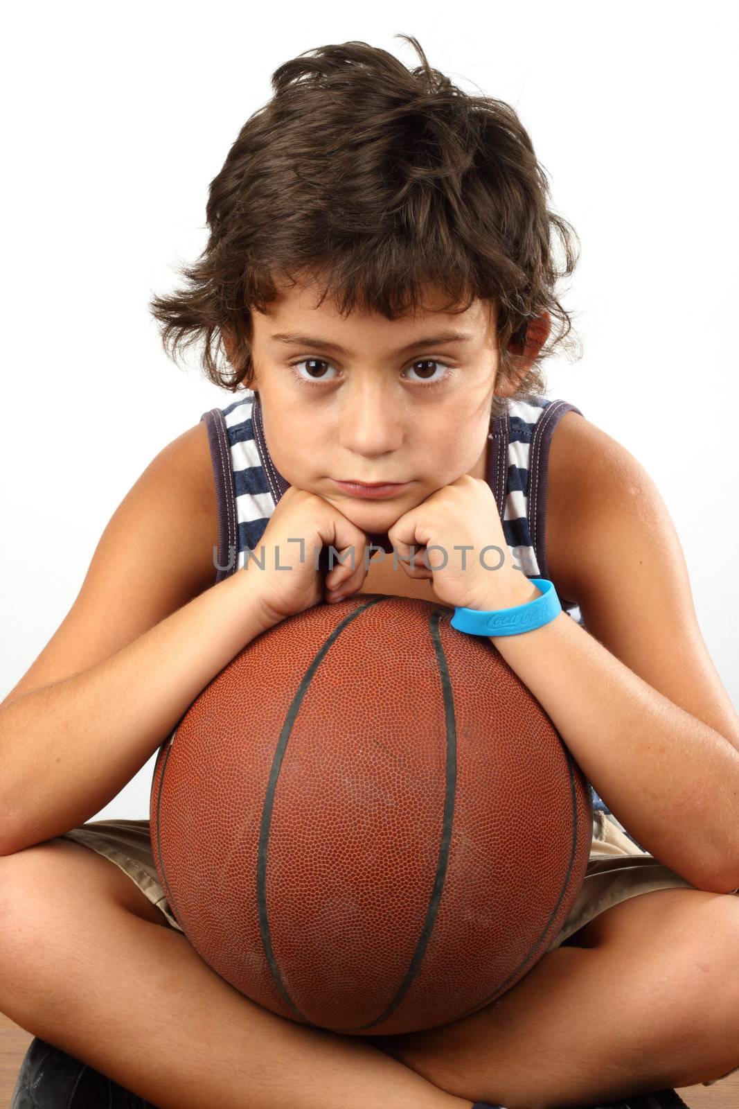 Young cute boy with basketball ball over white
