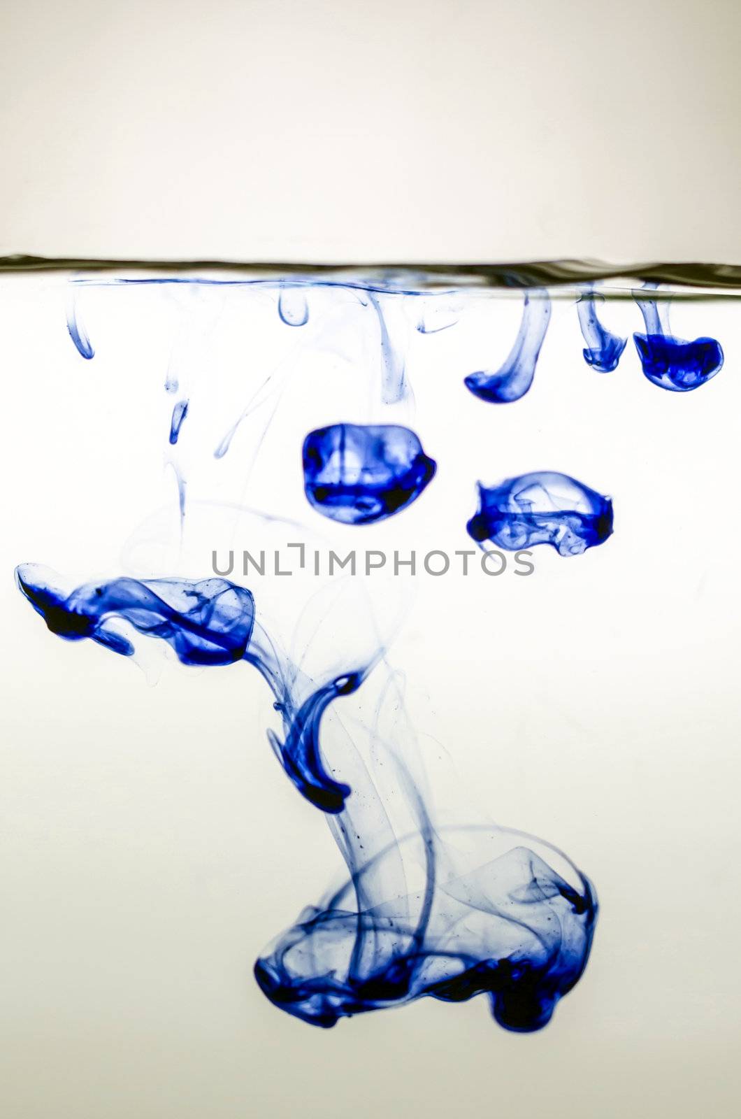 Blue ink in colored water on white background.