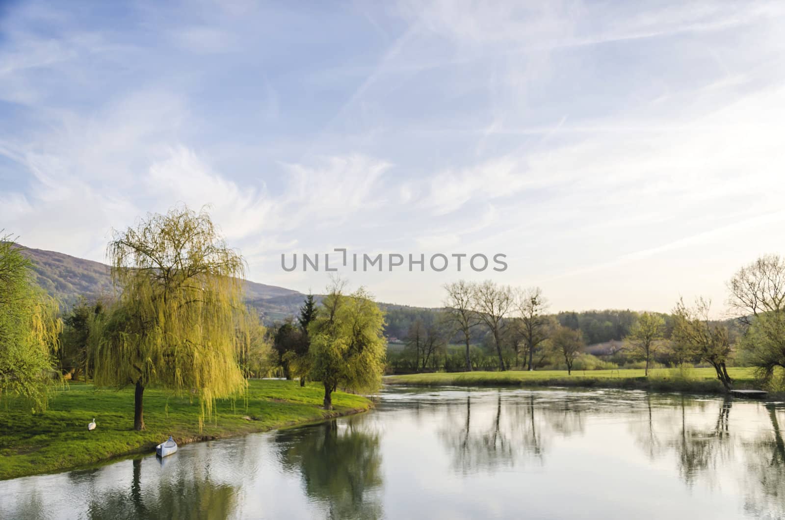 Scenic view on Krka river with blue canoe and a swan.