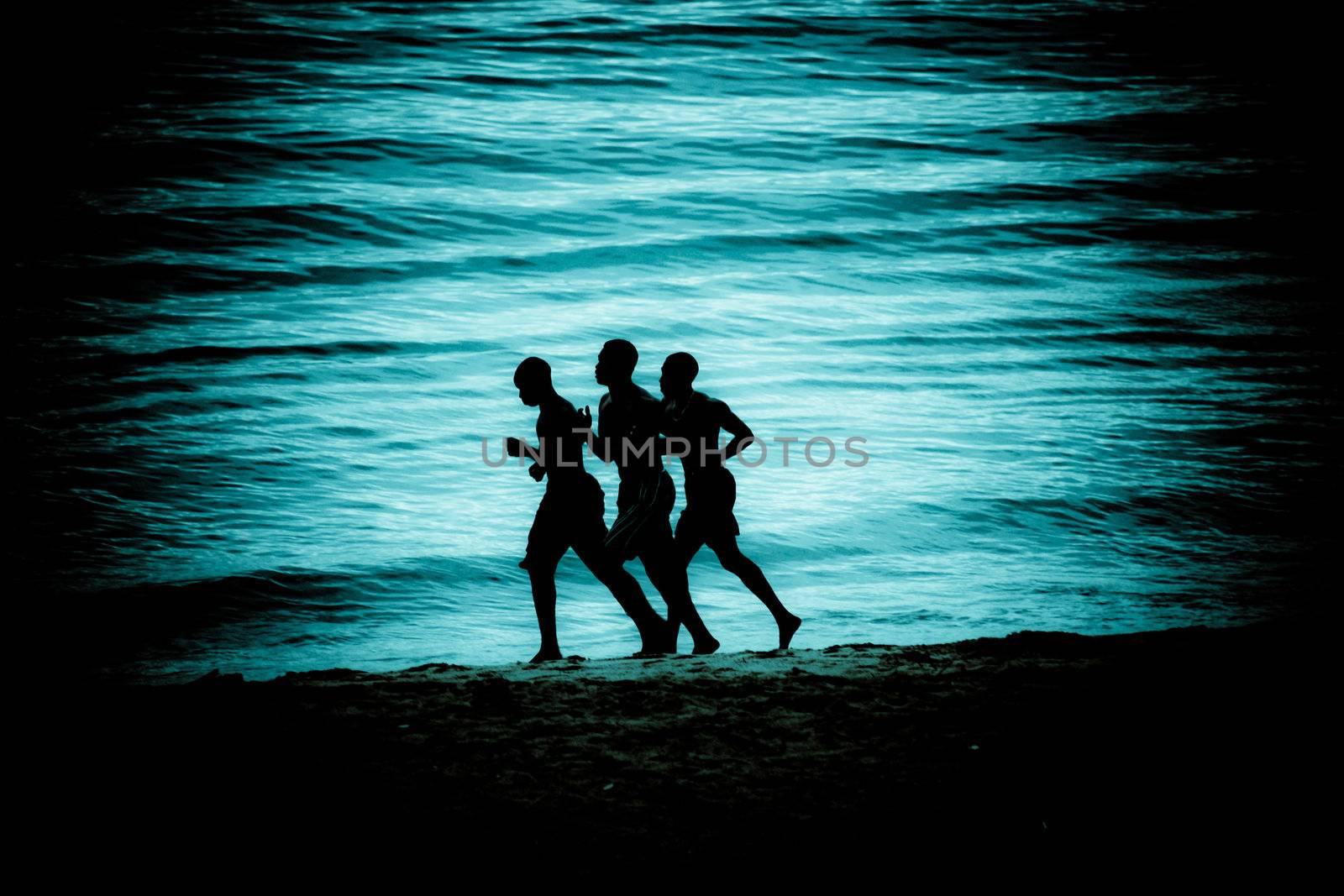 Men running along a beach