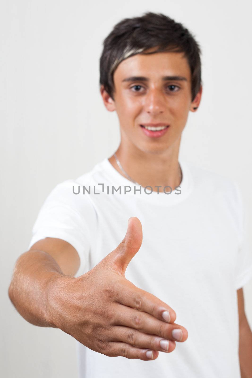 young swarthy man with  brown eyes giving hand for greeting on white background