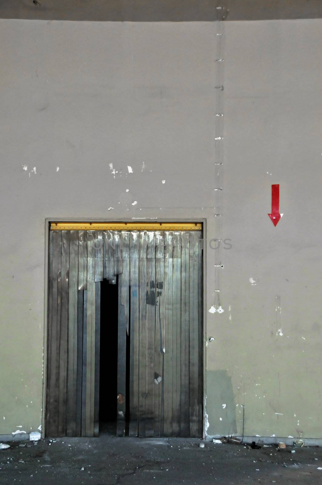 Door and arrow sign in abandoned factory. Abstract industrial interior.