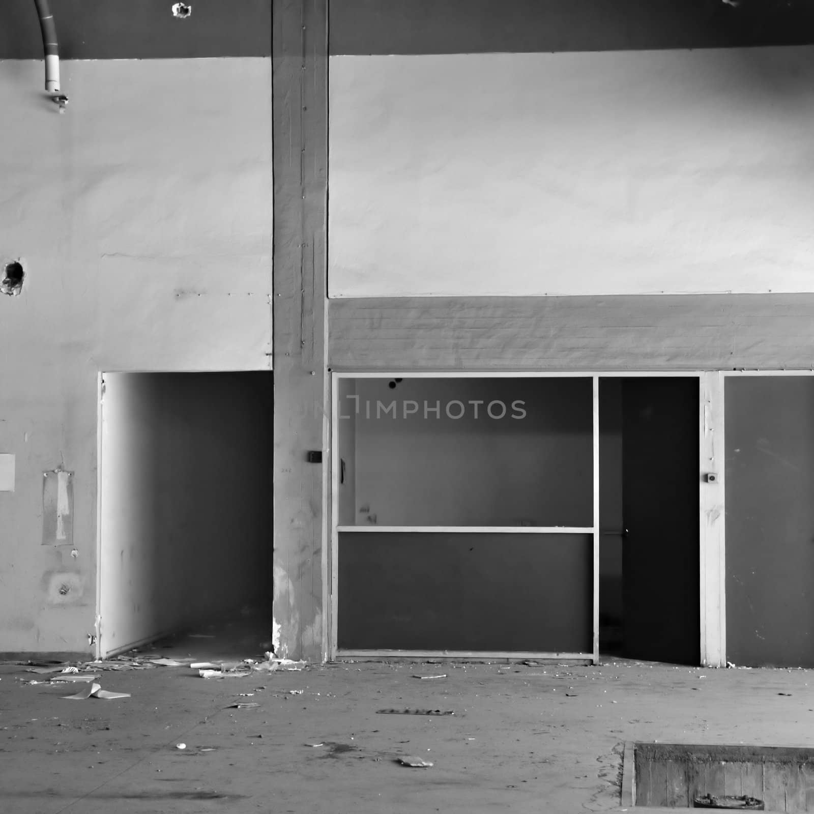 Empty room and concrete wall �n derelict factory interior. Black and white.
