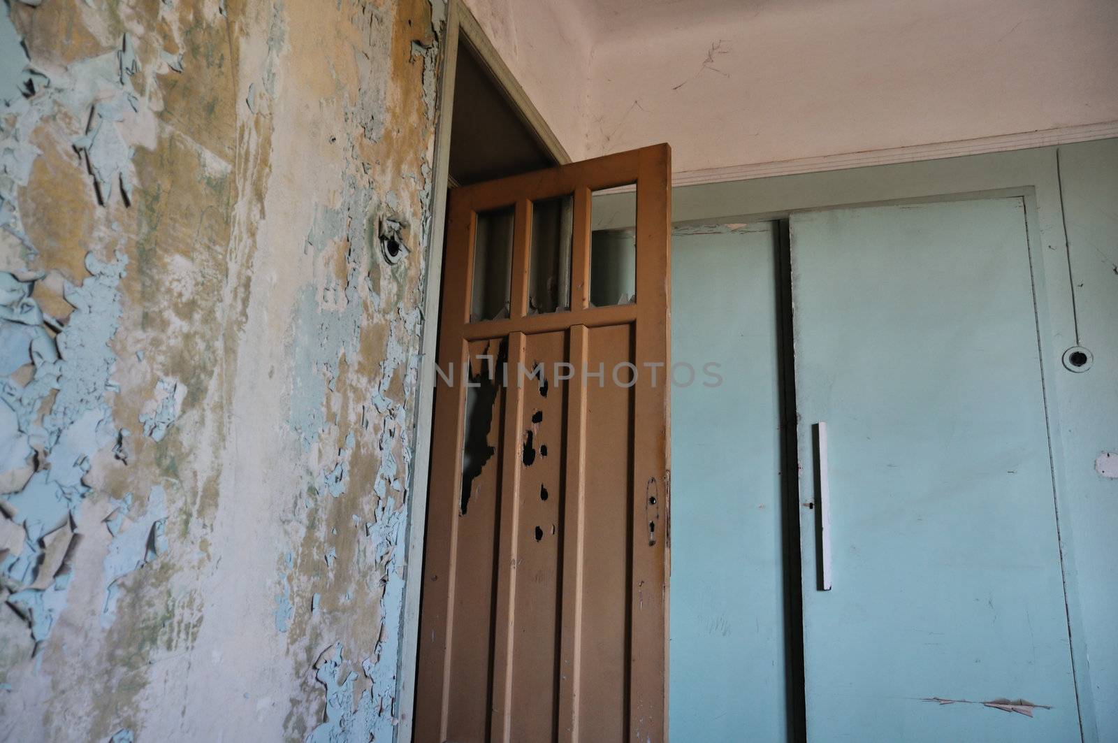Broken door peeling wall and closet in empty abandoned house interior.
