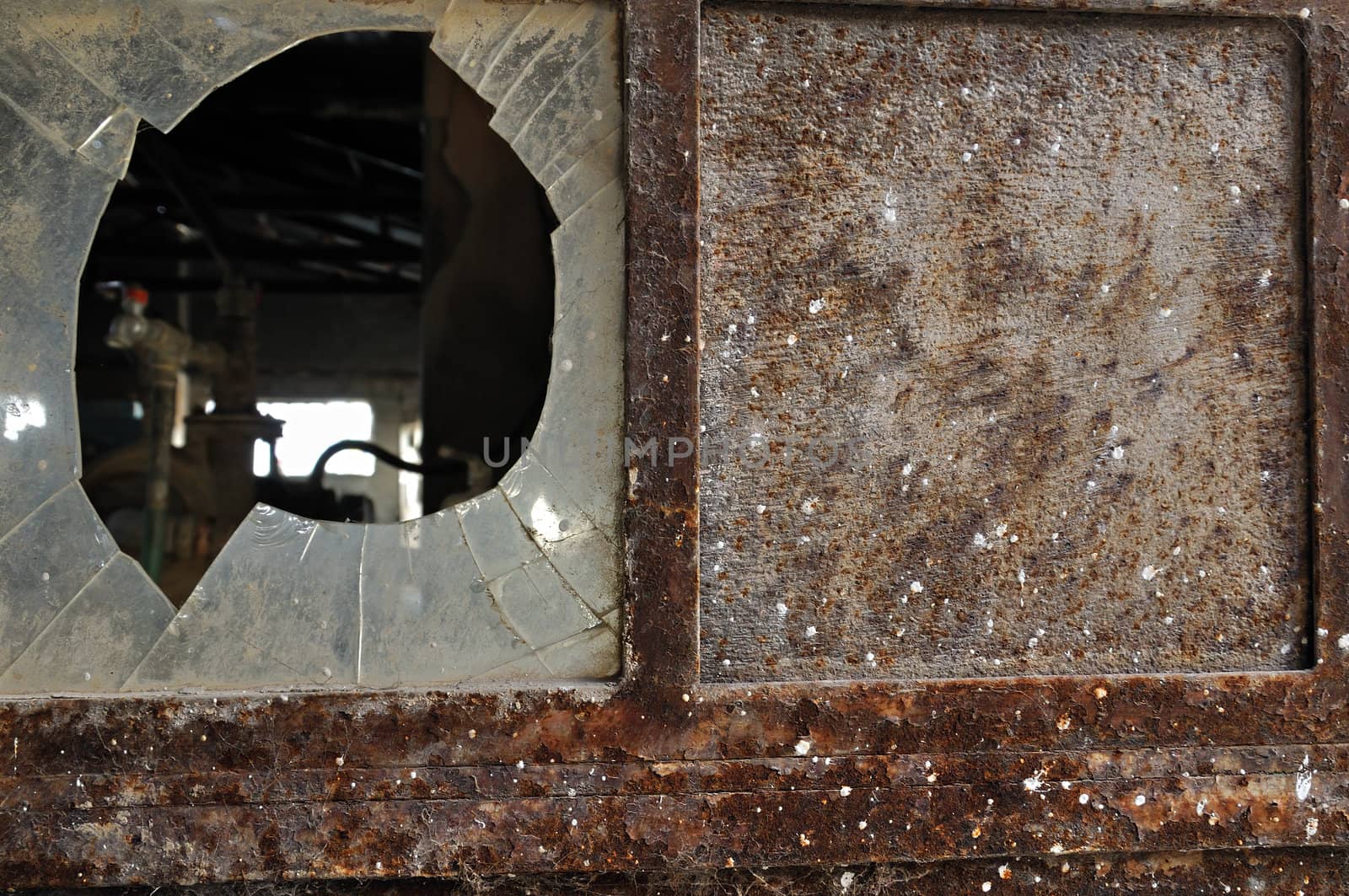 Rusty factory door and smashed glass. Industrial grunge background texture.