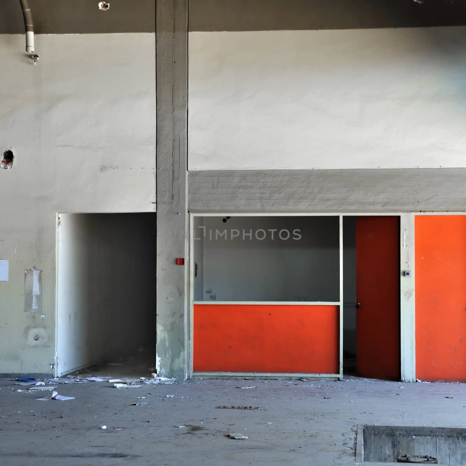 Empty room concrete wall and dark hallway in abandoned factory interior.