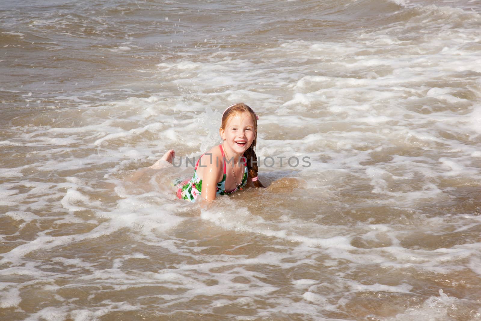 young girl enjoying the water in the surf near the beach