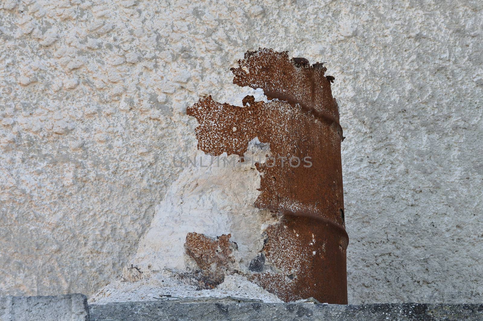 Deteriorated rusty barrel and spilled pile of marble dust powder.